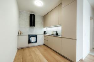 a kitchen with white cabinets and a wooden floor at Severna Residence in Banská Bystrica