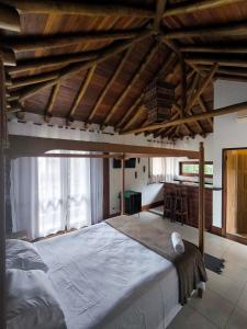 a bedroom with a large bed and a desk at Thai Pousada - Itamambuca in Ubatuba