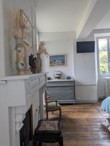 a room with a fireplace with a chair and a dresser at Chateau De Chaunac in Naves