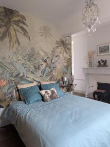 a bedroom with a blue bed with a tropical wallpaper at Chateau De Chaunac in Naves