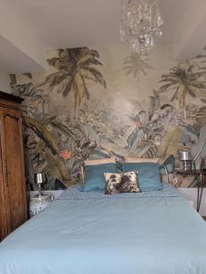 a bedroom with a blue bed with a mural of palm trees at Chateau De Chaunac in Naves