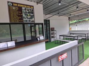 a restaurant with tables and chairs in a building at Khao Sok Station Hotel 109 in Khao Sok National Park