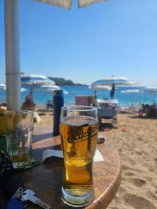 a glass of beer sitting on a table on the beach at Georgijevic 2 in Budva