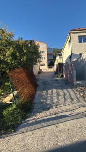 an empty street with a fence next to a building at Georgijevic 2 in Budva