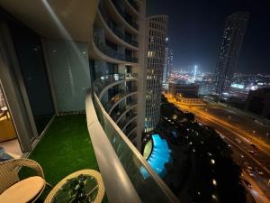 a balcony with a view of a city at night at Luxury Cozy Minimalist 1BR Haven Connected to Dubai Mall in Sabkhah