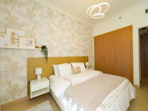 a bedroom with a large white bed in a room at Luxury Cozy Minimalist 1BR Haven Connected to Dubai Mall in Sabkhah +8 photos