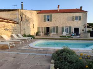 a villa with a swimming pool in front of a building at Villa Marie in Courçon
