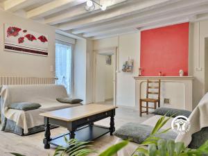 a living room with a couch and a table at LA MANCELLIERE in LʼHuisserie