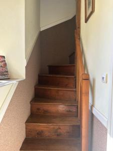 a stairway with wooden stairs in a house at Chez Vanessa Entrée privée avec escalier in Saint-Gervais-dʼAuvergne