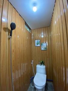 a bathroom with a toilet in a wooden wall at WIldFlower in General Luna