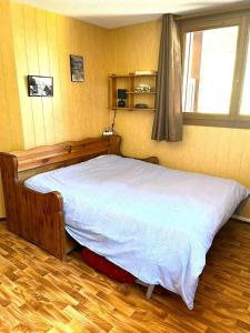 a bed in a bedroom with a wooden floor at CASA-Bois de Pisan at the foot of the slopes in Molines-en-Queyras +24 photos