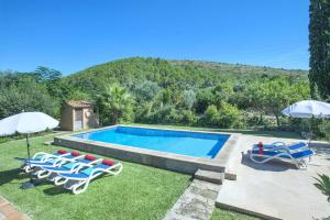 a swimming pool with lawn chairs and umbrellas at Villa Vinya by Villa Plus in El Port