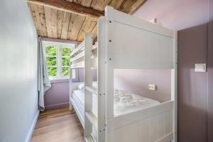 a white bunk bed in a room with purple walls at Kongshamn Gjestgiveri in Kirkehamn