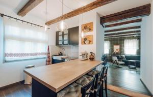 a kitchen with a large wooden island with chairs at 3 Bedroom Nice Home In Derezani 