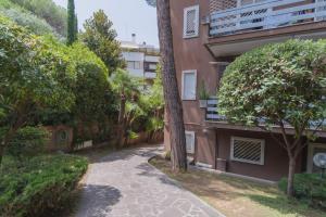 a walkway in front of a building with trees at Boutique Caravaggio in Rome