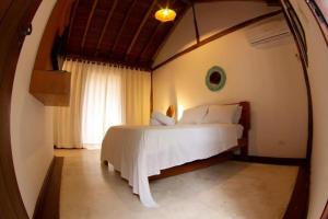 a bedroom with a white bed in a room at Thai Pousada - Itamambuca in Ubatuba