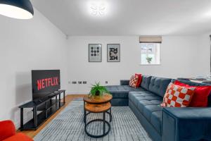 a living room with a blue couch and a table at 2 Bed Altrincham Flat Free Parking in Altrincham