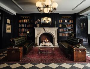 a living room with two chairs and a fireplace at Hotel 1928 in Waco