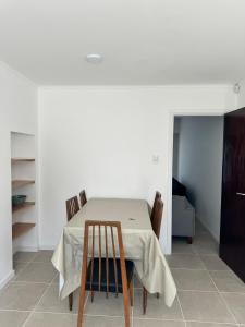 a dining room table with chairs and a white wall at La Mary in Mar del Plata