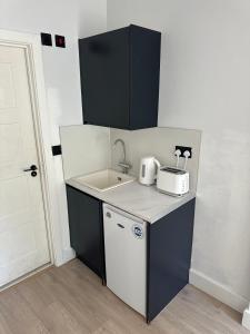 a small kitchen with a sink and a toaster at Comfort Rooms - Streatham Hill in London