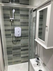 a bathroom with a shower and a sink at Comfort Rooms - Streatham Hill in London