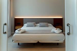 レオンにあるARVA Santiago Leónのベッドとタオル2枚のある寝室