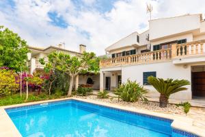 a villa with a swimming pool in front of a house at Chalet Muro en Mallorca in Playa de Muro