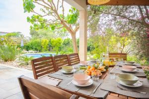 a wooden table with food and fruit on a patio at Chalet Muro en Mallorca in Playa de Muro