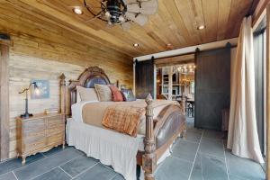 a bedroom with a bed and a wooden ceiling at The Barn House in Lakeside