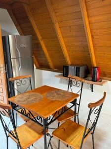 a kitchen with a table and a refrigerator at Chalé Dovale in Sambaqui +7 photos