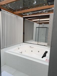 a white bath tub in a room with some windows at Chalé Dovale in Sambaqui