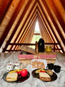 a table with plates of food and a basket of bread at Chalé Dovale in Sambaqui