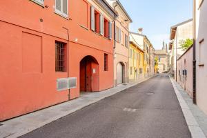 an empty street with orange and yellow buildings at Appartamento La Sosta in Piacenza