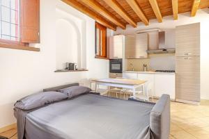 a bedroom with a bed and a table in a kitchen at Appartamento La Sosta in Piacenza