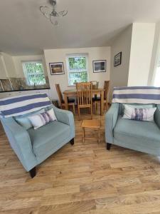 a living room with two blue chairs and a table at Bobbi's Bothy in Newcastle