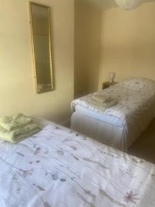 una camera da letto con due letti e uno specchio sul muro di Town centre flat near harbour attractions and restaurants a Maryport