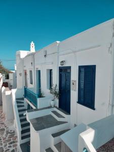 a row of white buildings with blue doors and stairs at eleni's cozy appartment in Kastron