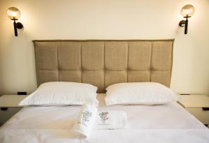 a bed with two white pillows and a headboard at Villa Terra Promessa in Ulcinj