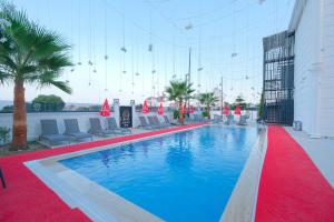 a swimming pool with chairs and a red carpet at Black Royal Belek in Belek +35 photos