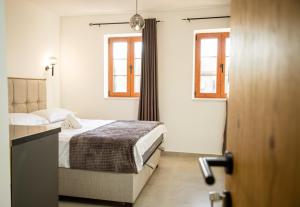 a bedroom with a bed and two windows at Villa Terra Promessa in Ulcinj +82 photos