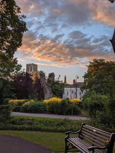 a park bench in a park with a castle in the background at Swallow cottage in Howden