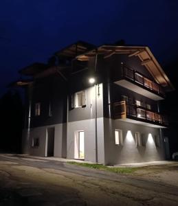 a building with a light on the side of it at night at Casa Nadia - Val di Sole Apartment in Piano