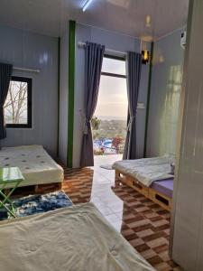 two beds in a room with a window at SORA HOME STAY Ke Ga in Láng Văn Kê