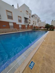a swimming pool with a sign in front of a building at Bright Flat w/ Terrace & Pools by HostWise in Tavira