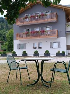 a table and two chairs in front of a building at Casa Nadia - Val di Sole Apartment in Piano