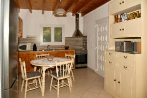 a kitchen with a table and chairs in a kitchen at Barbara's Beach House in Lefkímmi +36 photos