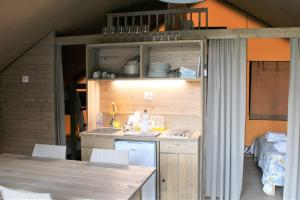 a kitchen with a sink and a table in a house at Village Glamping Biscione in Petrosino