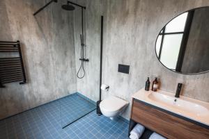 a bathroom with a toilet and a sink and a mirror at Centrum Hotel in Akureyri