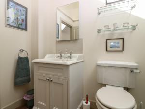 a bathroom with a white toilet and a sink at The Barn, Lower Lodge in Cupar +12 photos
