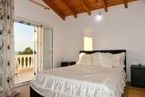 a bedroom with a large bed and a balcony at Barbara's Beach House in Lefkímmi
